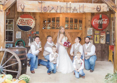 Bride with groomsmen outside the doors of the Townhall building.