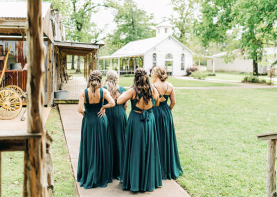 group of 4 bridesmaids walking towards the chapel.