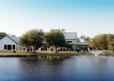 Farmhouse seen at a distance with a pond in front.