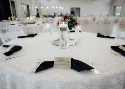 close up of the table setting with place cards, centerpieces and silverware.